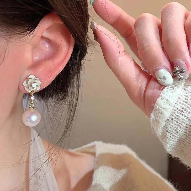Close-up of women's camellia pearl flower stud earrings in alloy with butterfly clasp