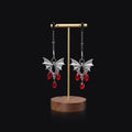 Silver bat-shaped nipple clamp with ruby accent detail and adjustable pressure mechanism