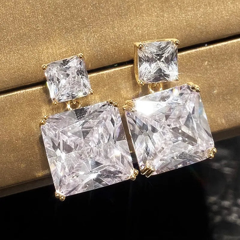 A pair of geometric square-shaped copper earrings for women, shown in white gold and gold colour options.