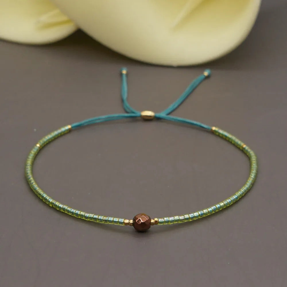 Close-up of a handmade Bohemian women's bracelet with colourful semi-precious stone and glass beads on a geometric string.