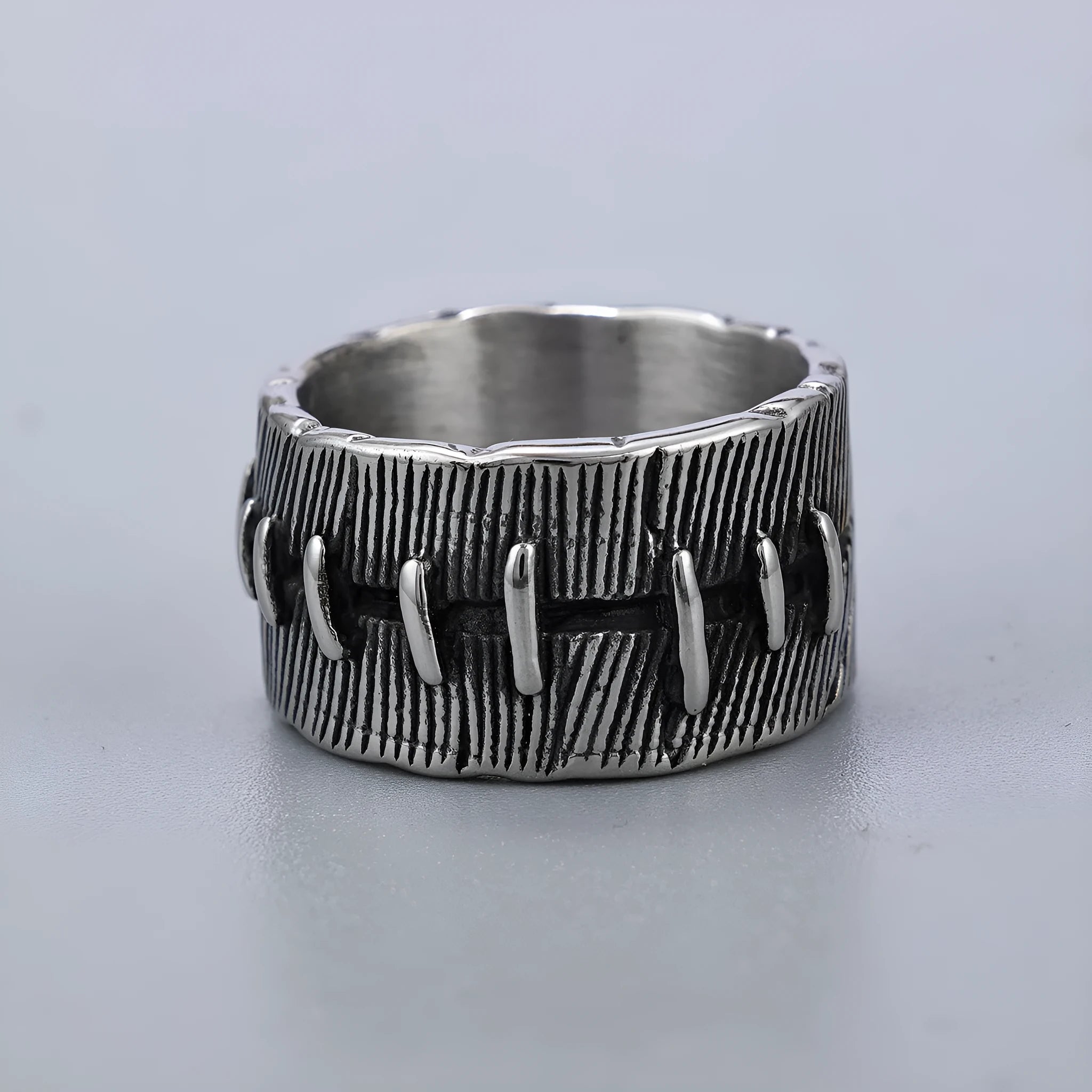 Geometric titanium steel double ring in a dark punk style with a U-shape and stitched design.
