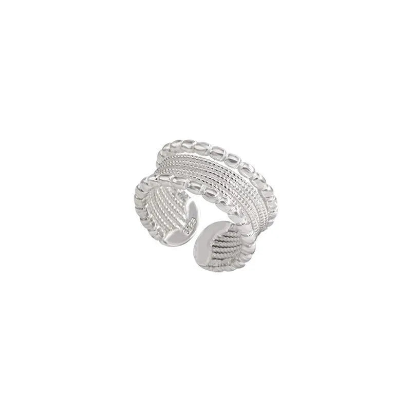Copper ring with geometric woven twisted design and adjustable opening.