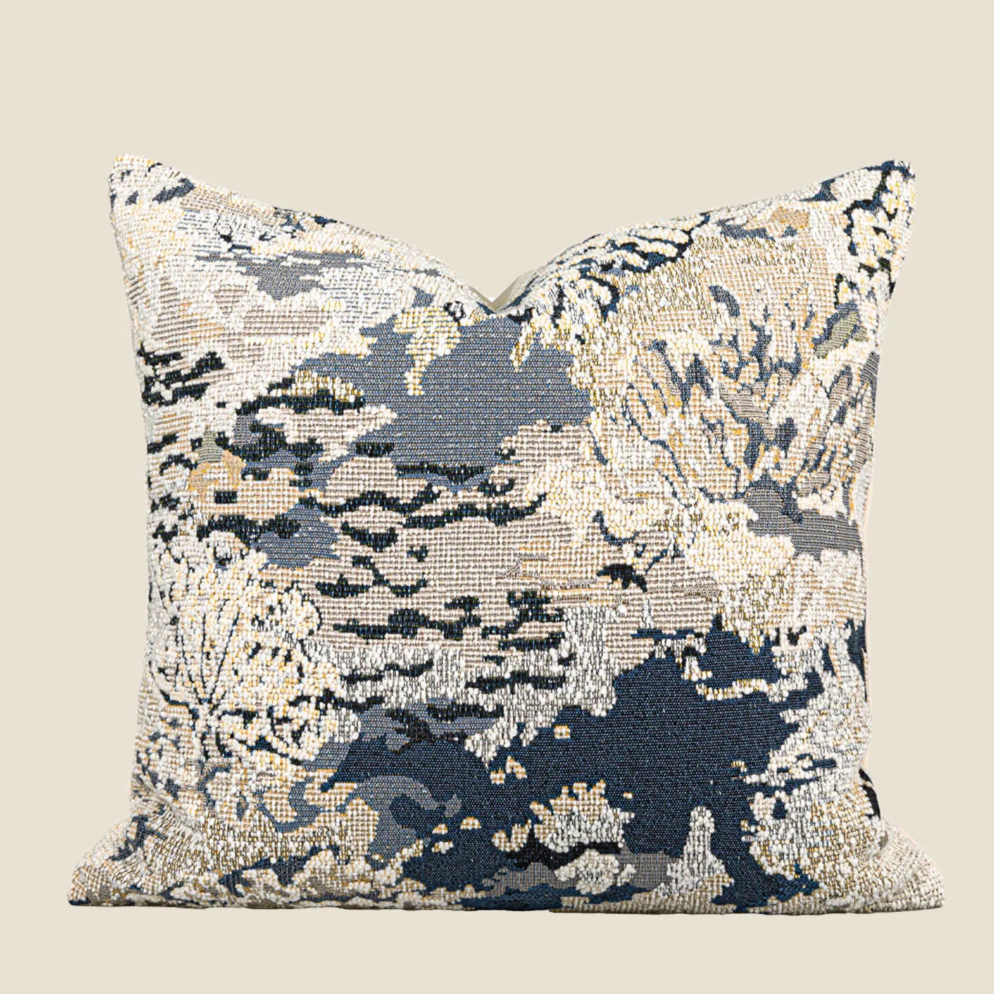 Antique blue square cushion with abstract botanical flower pattern on a grey sofa.