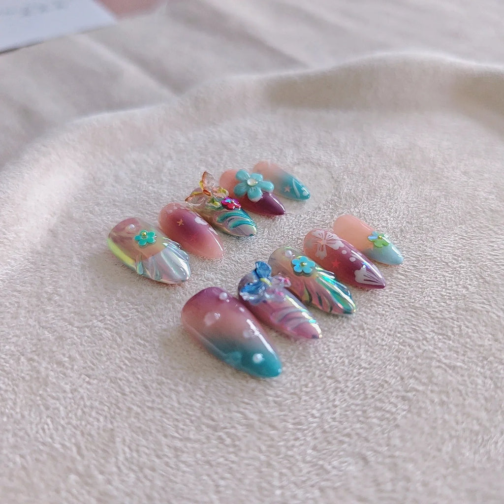 Handmade nail art sculptures with embossed floral and butterfly patterns in almond shapes