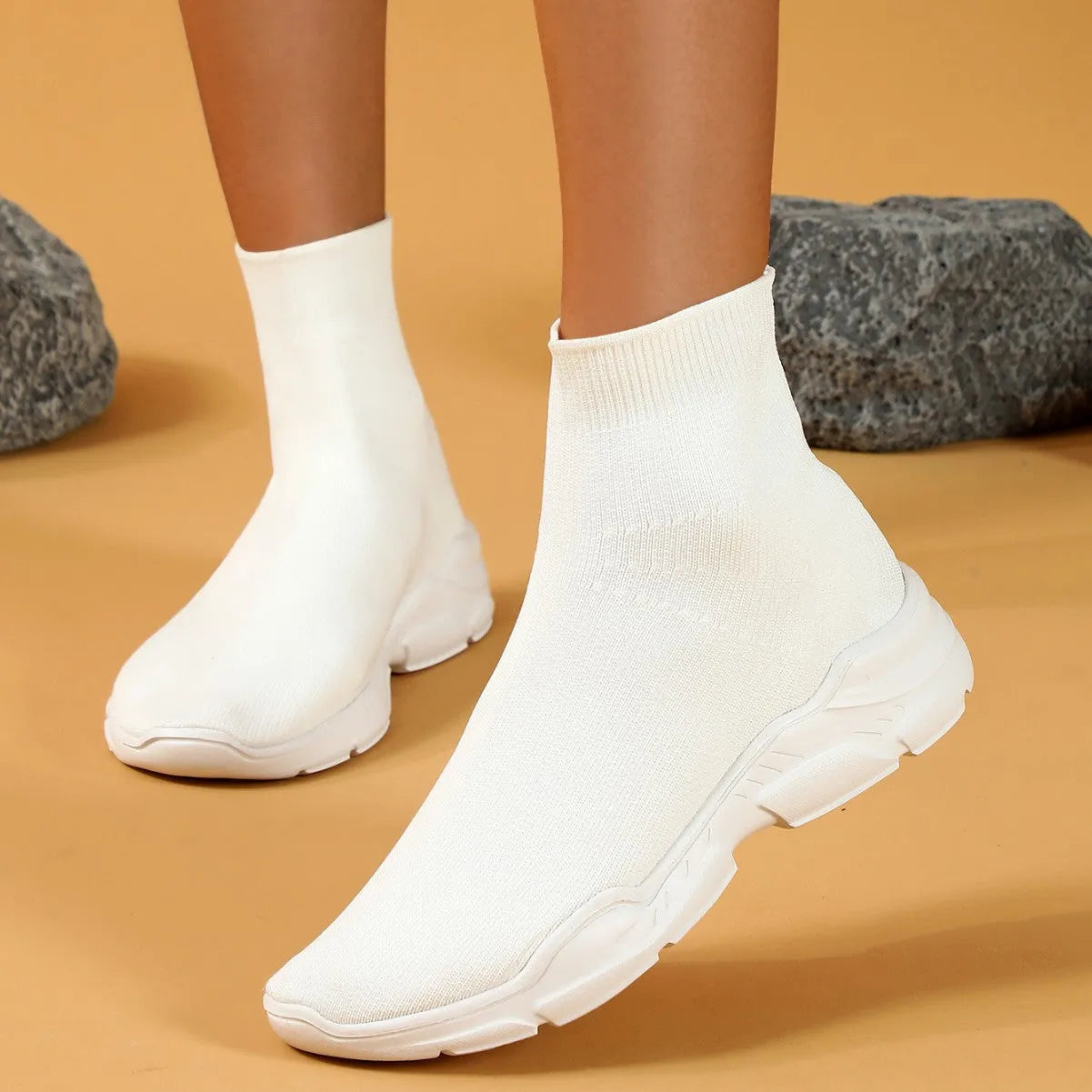 Thick-soled slip-on casual shoes in black with fabric upper, mid-top design, and round toe.