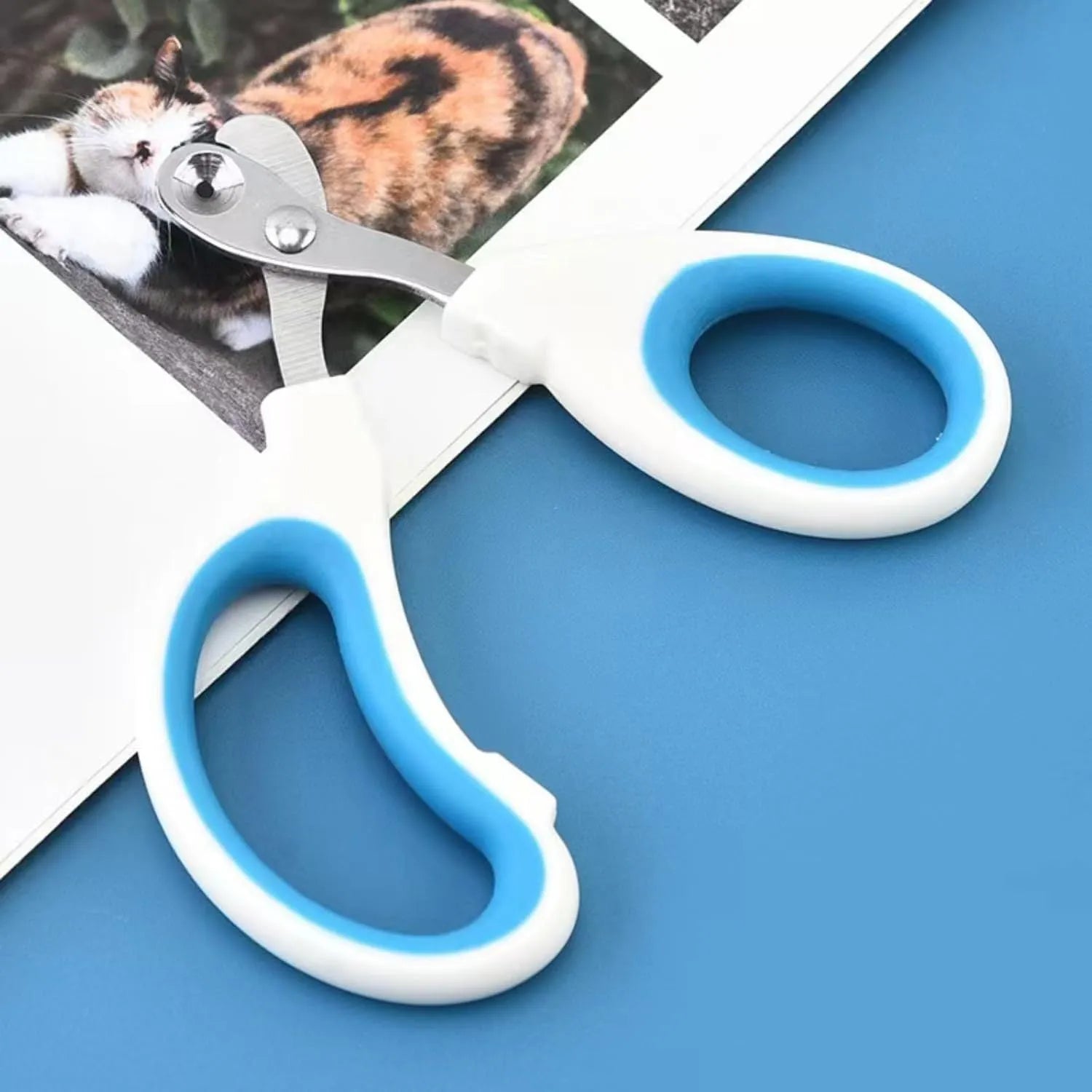 Blue pet nail clippers with a circular cutting hole and non-slip handle for trimming cat nails.