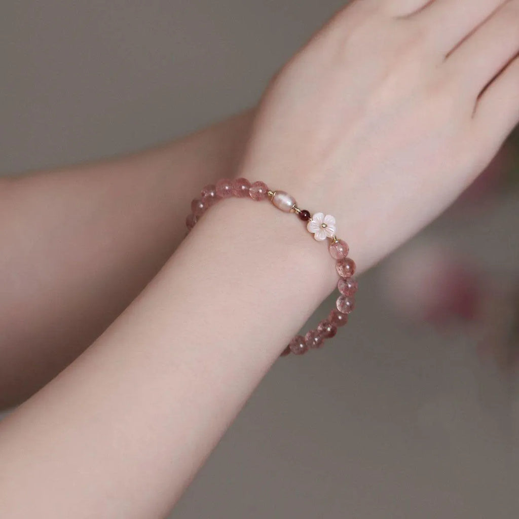 Strawberry quartz peach blossom crystal bracelet with floral design on wrist