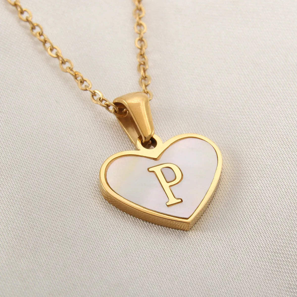 Gold plated heart-shaped necklace with a personalised initial letter and white shell detail on a 50cm adjustable chain.