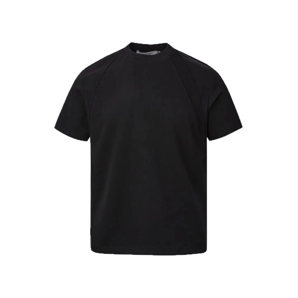 Man wearing a loose fit black short sleeve top with visible air layer stitching detail.