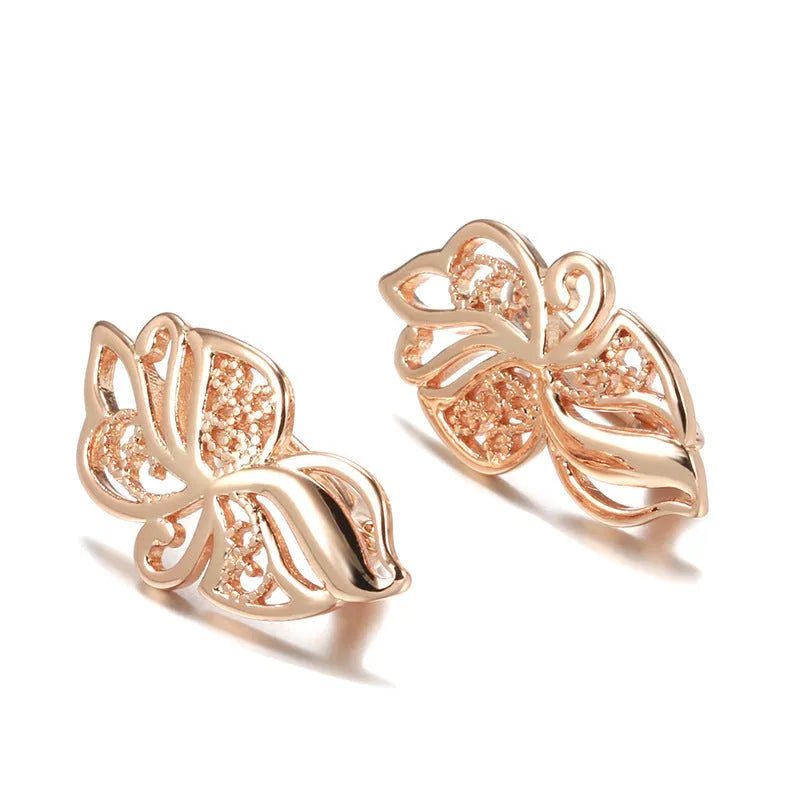 Pair of rose gold hollow carved geometric earrings with rhinestone accents on copper base