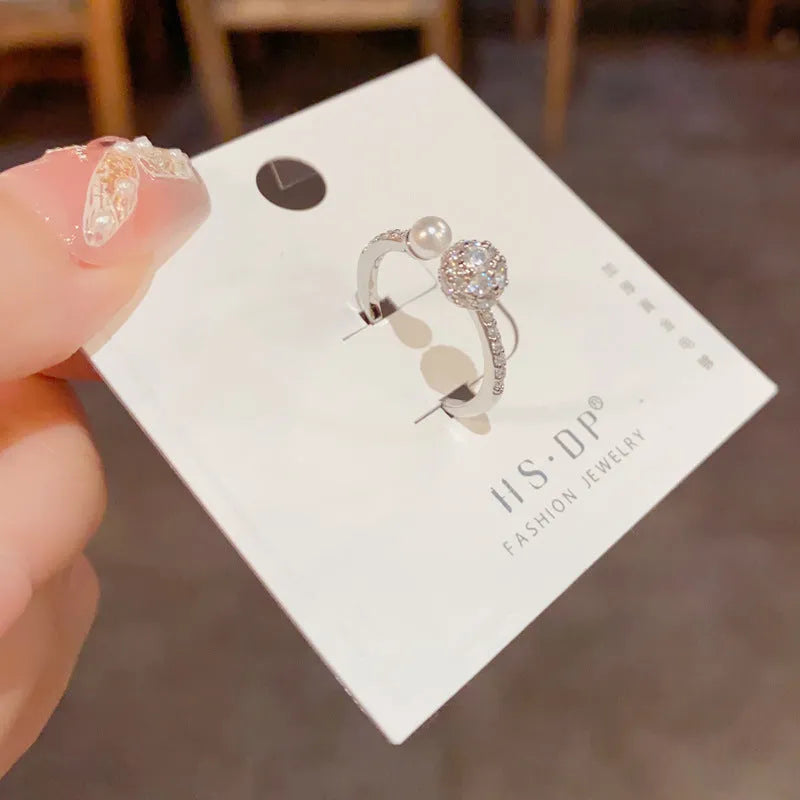 Open-end pearl ring with round zircon stones in gold or silver plating, geometric shape