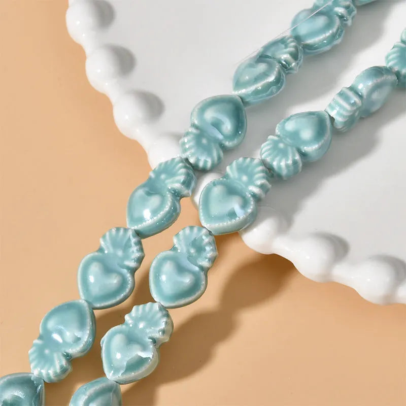 Assorted small ceramic torch beads in multiple colours on a white background.