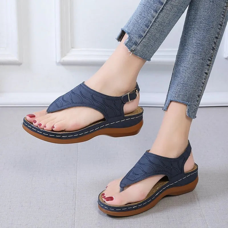 Women's red wedge heel sandals with an adjustable buckle strap on a white background