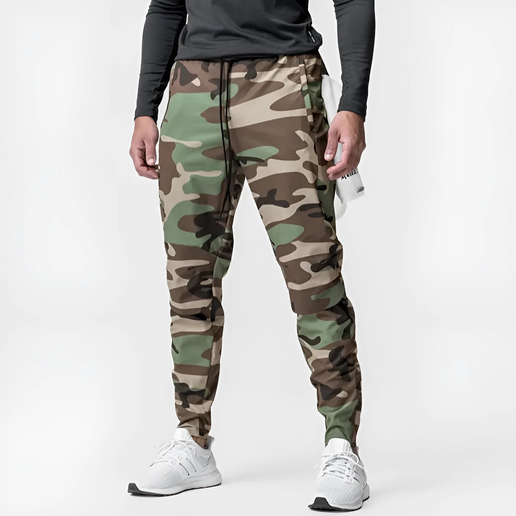 Man wearing dark grey loose-fit ankle-tied polyester running trousers for fitness.