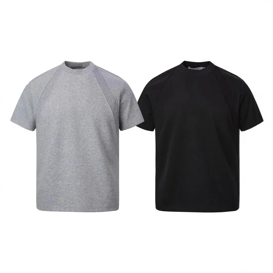 Man wearing a loose fit black short sleeve top with visible air layer stitching detail.