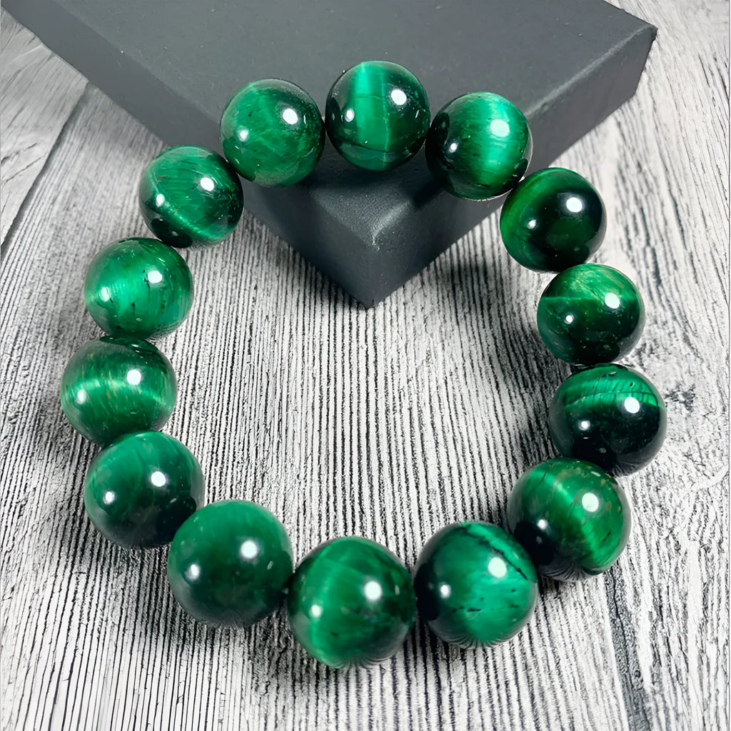 Green tiger eye stone bracelet with polished geometric beads on a wrist.