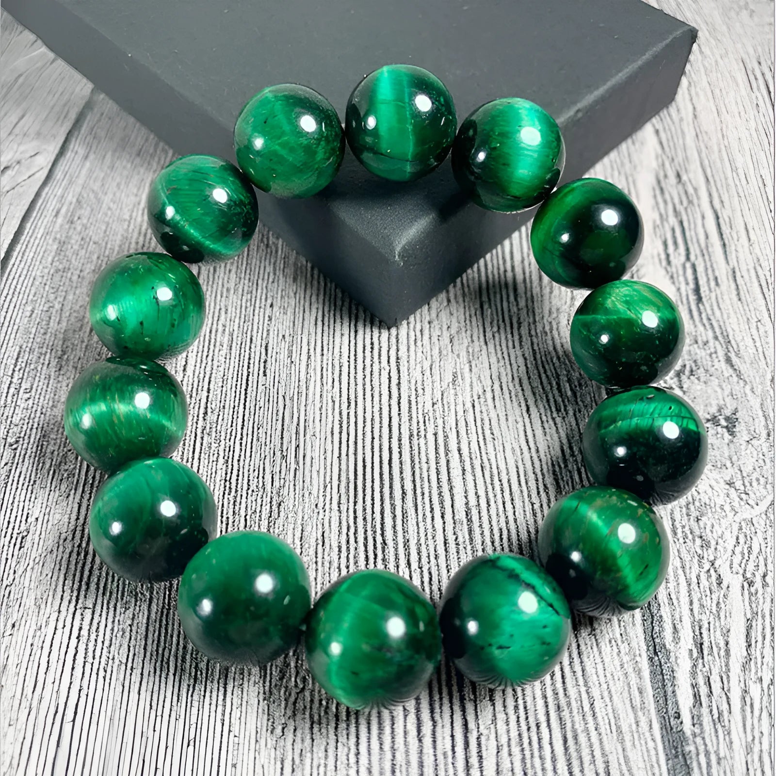 Green tiger eye stone bracelet with polished geometric beads on a wrist.