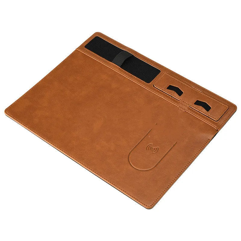 Pink wireless charging mouse pad with integrated mobile phone holder on a desk.