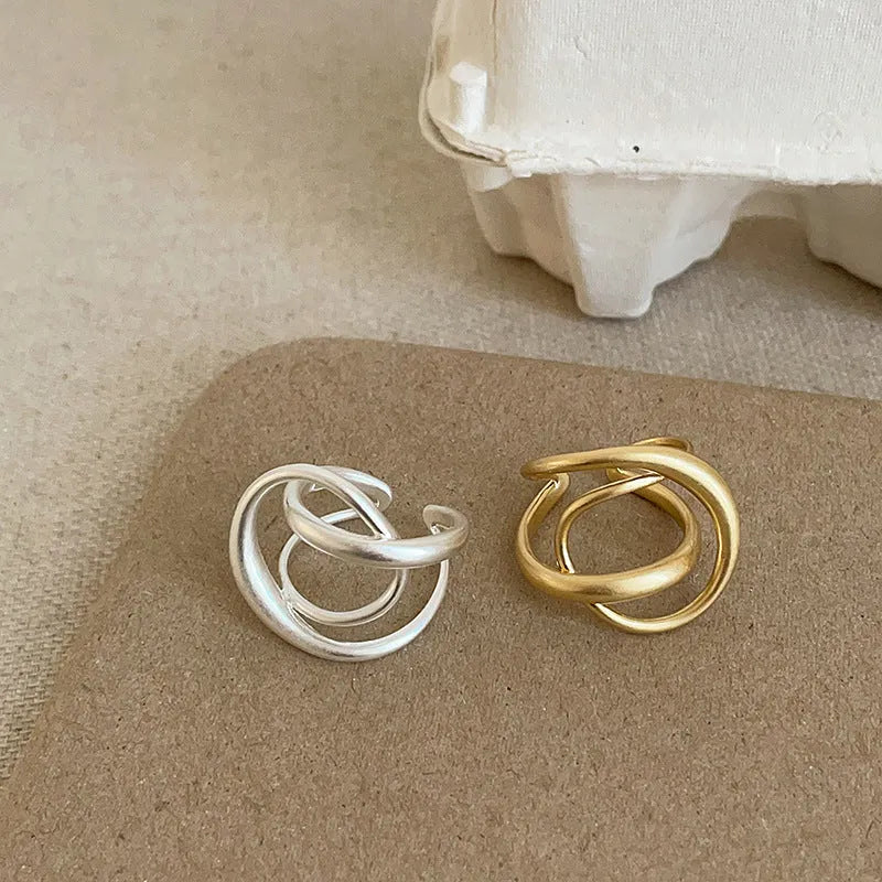 Geometric open ring with interlaced design in matte gold metal finish