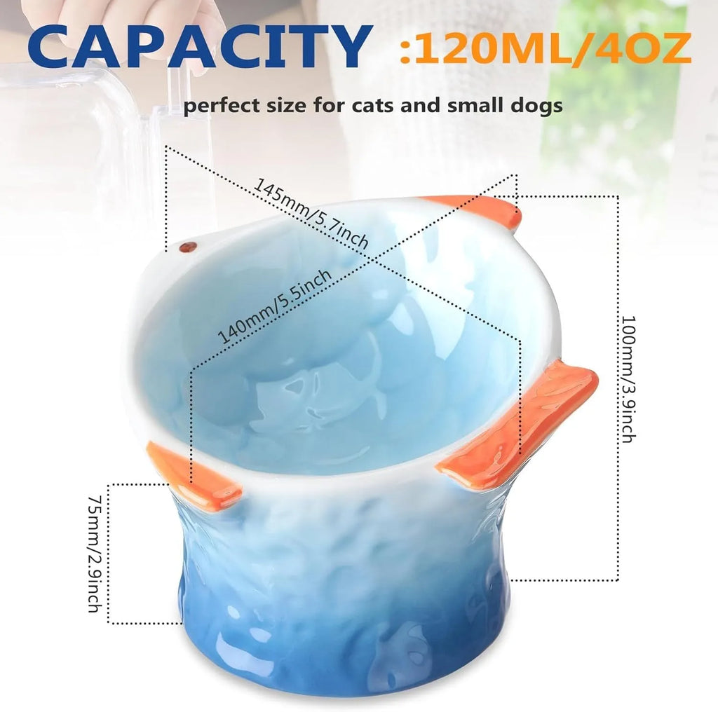 Set of four blue fish-shaped ceramic cat bowls with a tilted angle on a flat surface.