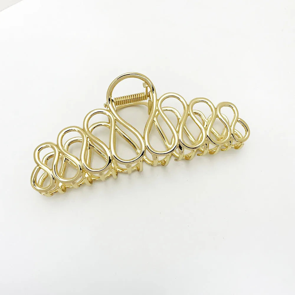 Minimalist large hair clip with electroplated finish and tassel detail.