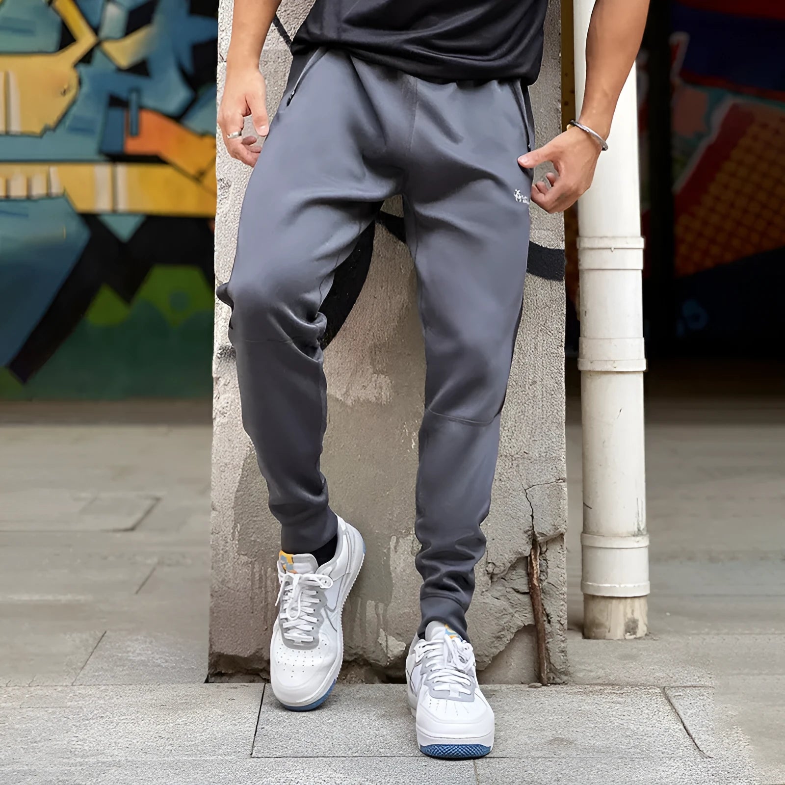 Men's deep gray stretch polyester sweatpants with panel zip pockets, side view