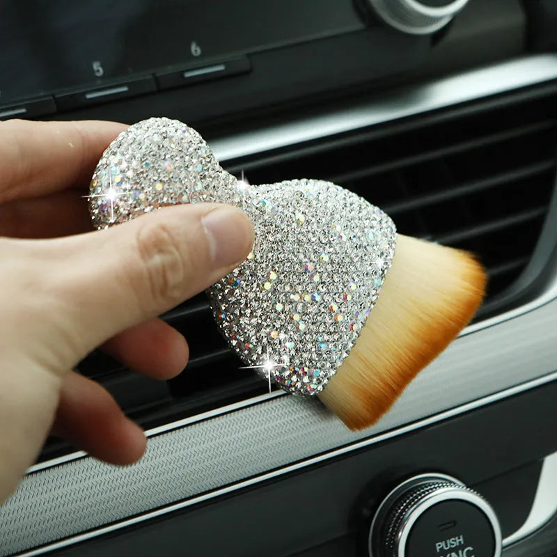 White PVC car interior cleaning brush on a car dashboard, showing its compact size and soft bristles.