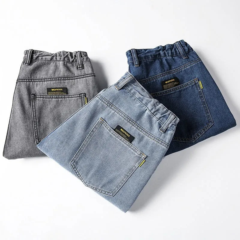 Man wearing dark blue loose straight leg cotton jeans with a mid waist and zipper fly.