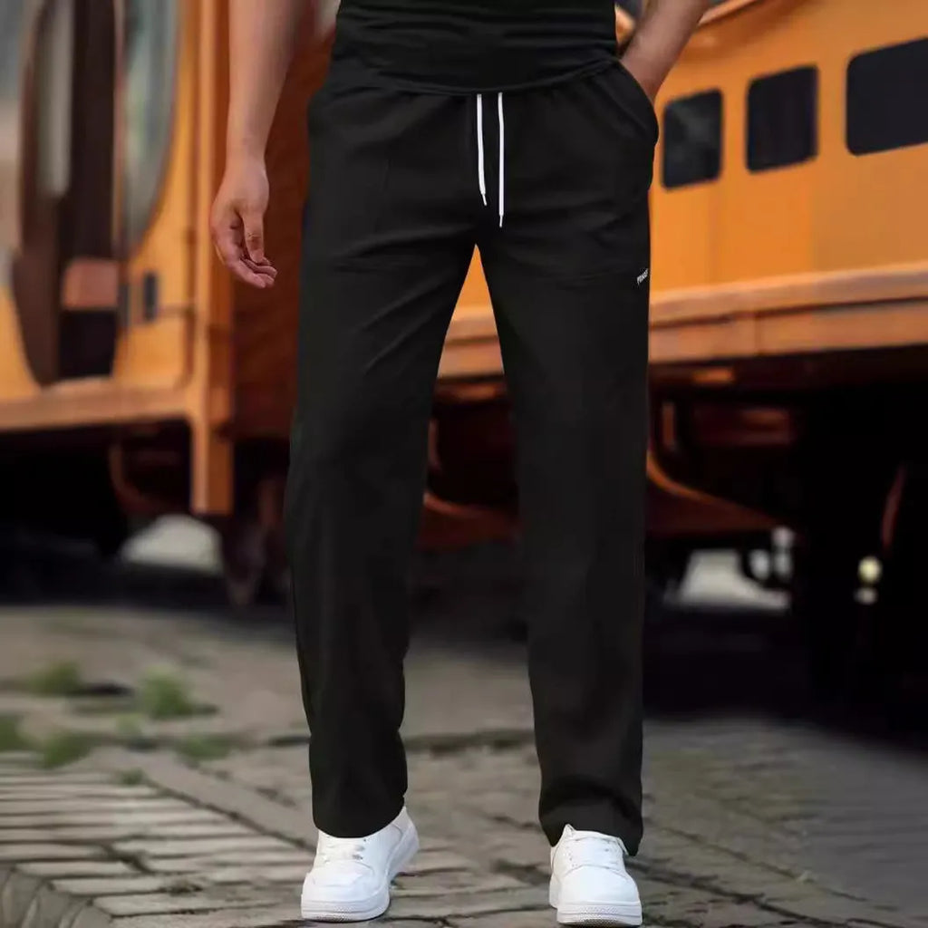 Man wearing lightweight grey polyester trousers, showcasing fit and casual style for spring or autumn.