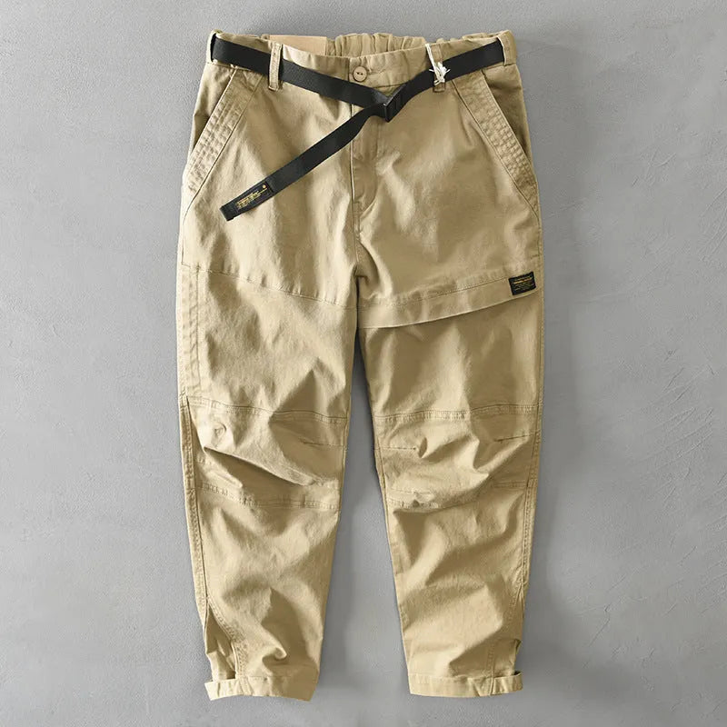 Man wearing khaki coloured loose fit cotton overalls with a mid waist design