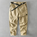 Man wearing khaki coloured loose fit cotton overalls with a mid waist design