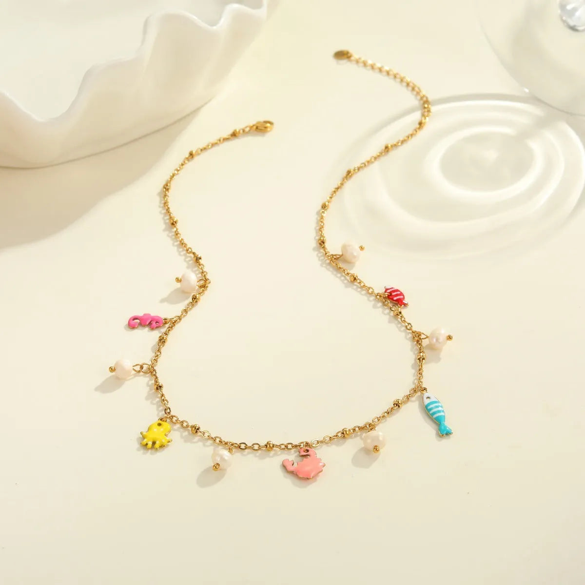 Stainless steel geometric pendant necklace with 18K electroplate and matching alloy bracelet on surface
