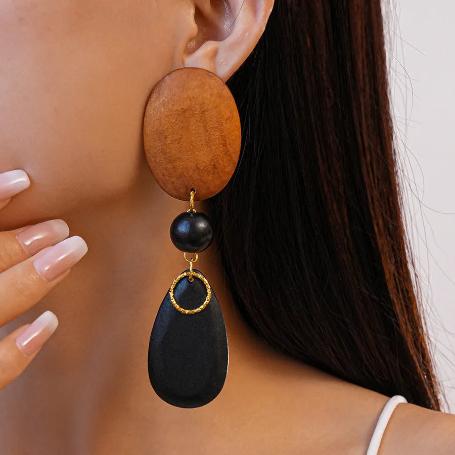 Pair of brown and black wooden elliptical retro style earrings on a silver backing.
