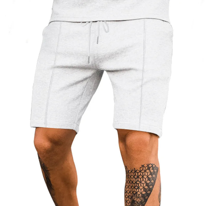 Solid colour polyester five-point sports shorts in Khaki, side view, showing elastic waist and above-knee length
