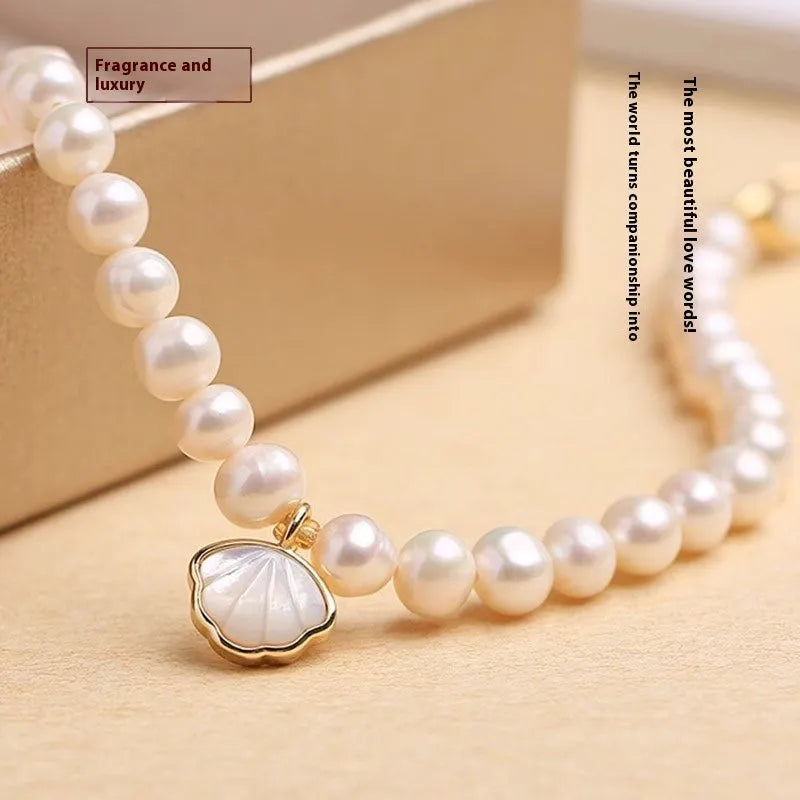 Close-up of a women's freshwater pearl fan bracelet on a wrist, showing elastic string and chain fastening options.
