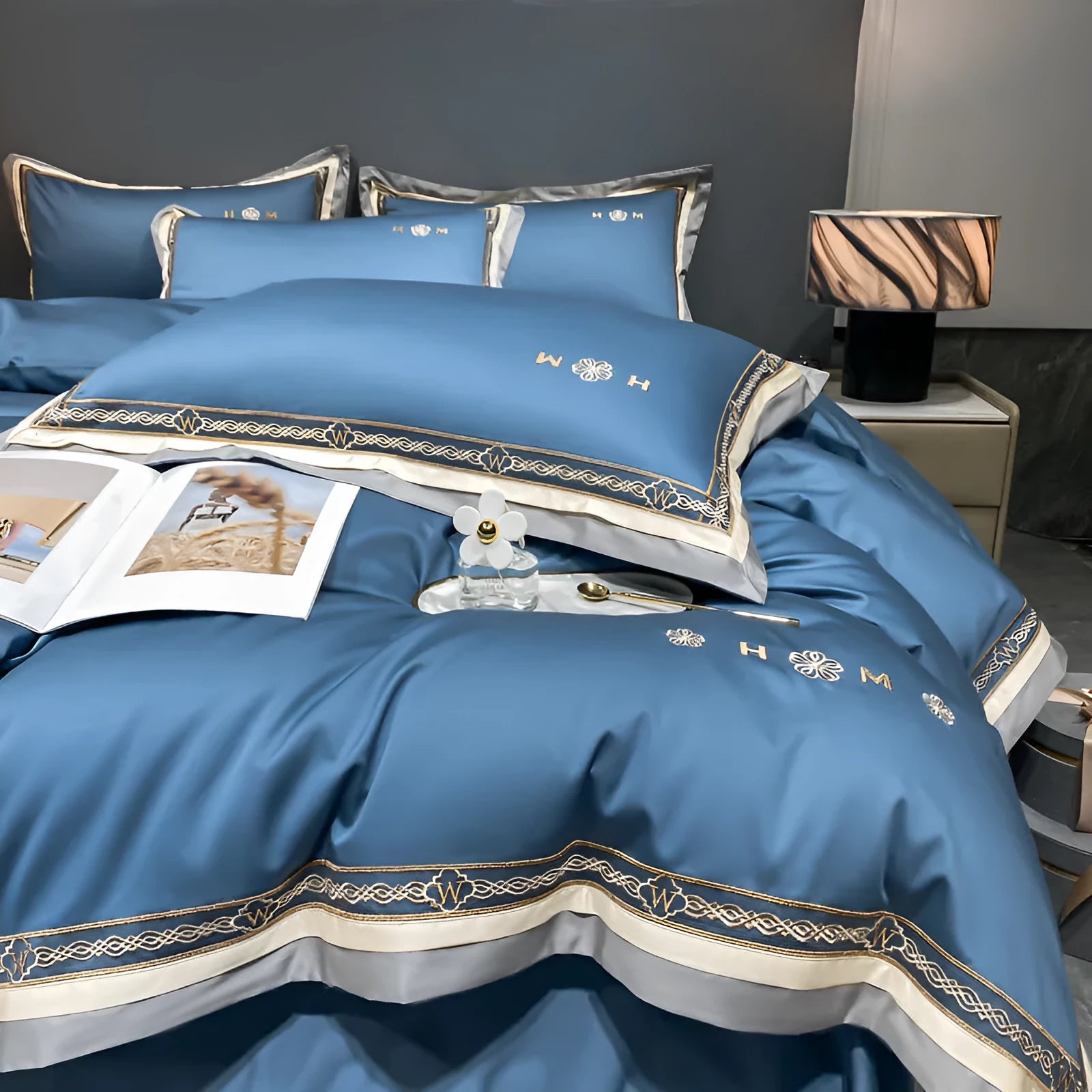 All-cotton light luxury four-piece bedding set with embroidery, available in multiple colours, on a bed