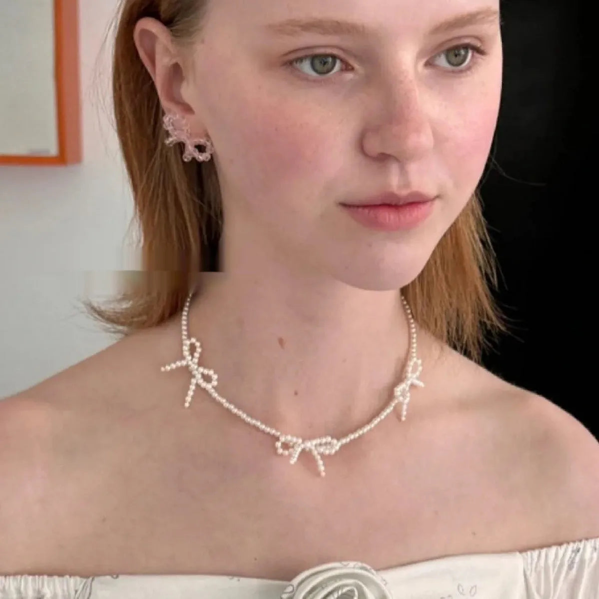 White adjustable pearl necklace with bow detail measuring 31-40cm