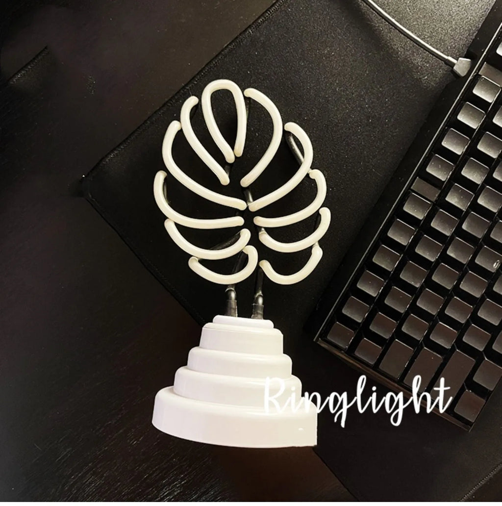 White bamboo-shaped desktop lamp emitting green light with USB power cable