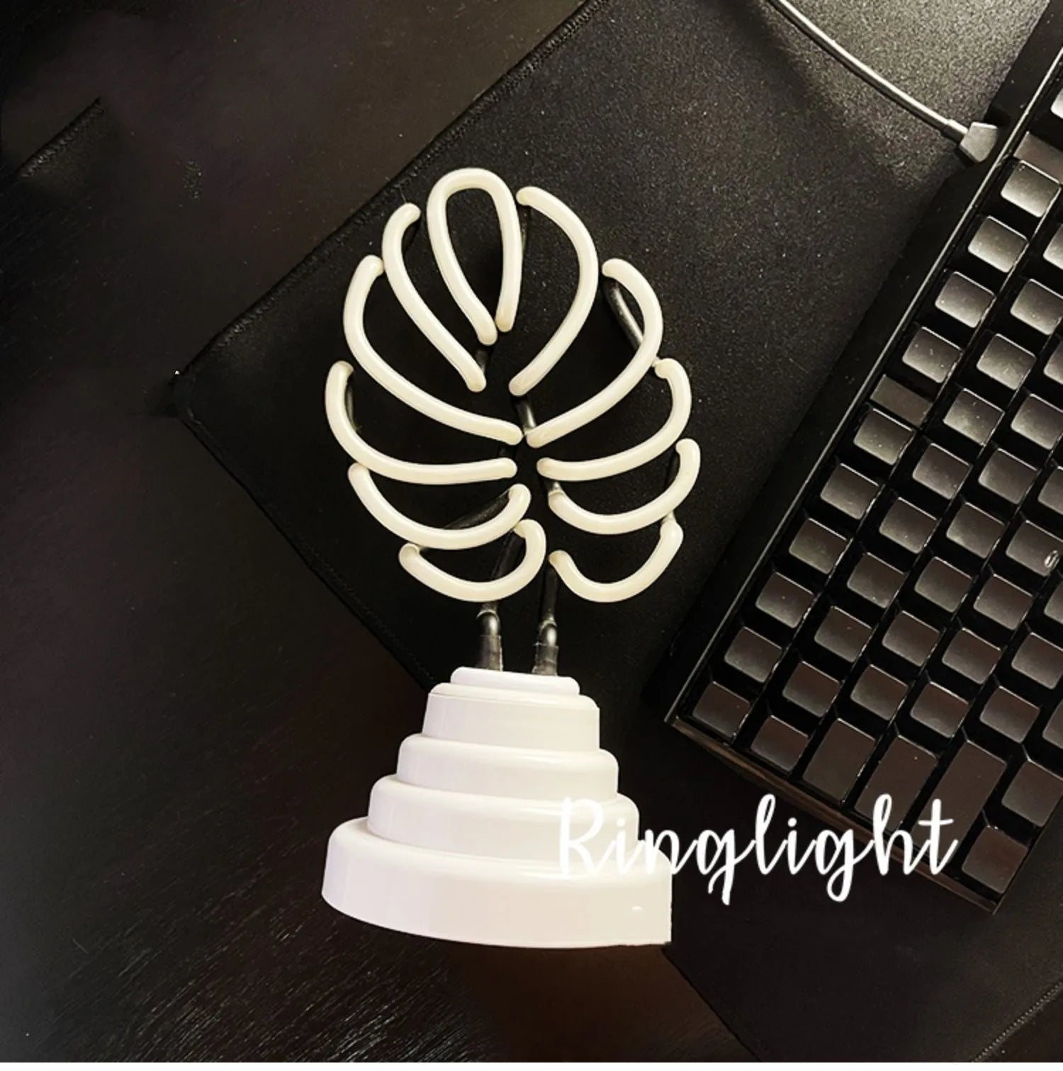 White bamboo-shaped desktop lamp emitting green light with USB power cable