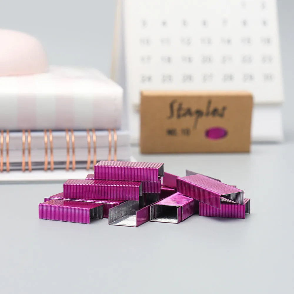 Box of 1000 metal office staples showing black, purple, rose gold, and rose red colour options.