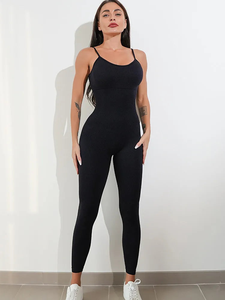 A woman wearing a black sleeveless jumpsuit with thin spaghetti straps and a backless design.