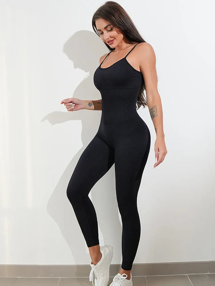 A woman wearing a black sleeveless jumpsuit with thin spaghetti straps and a backless design.