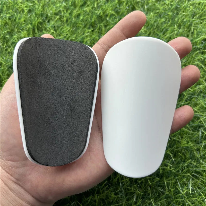 Extra small mini football shin guards measuring 8x5cm in black and white plastic construction
