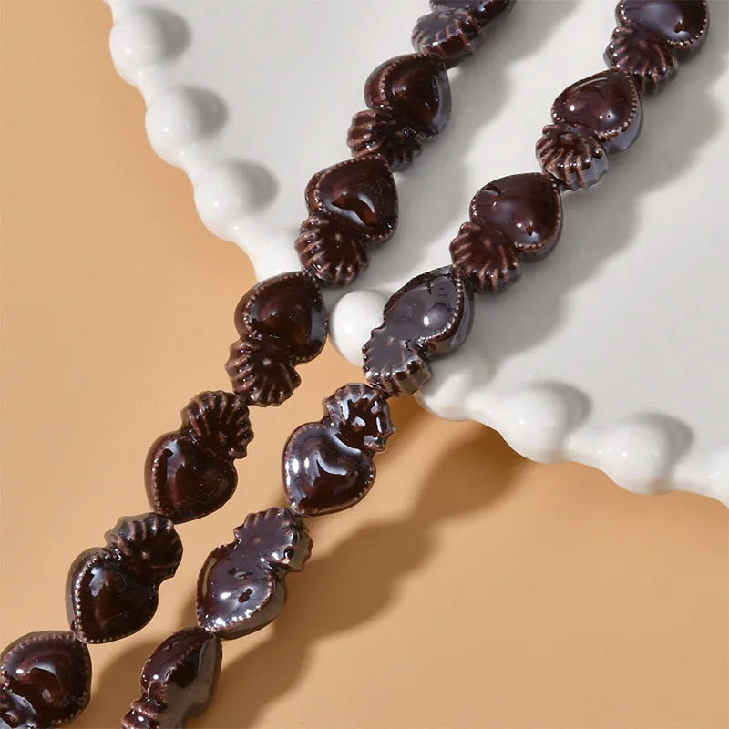 Assorted small ceramic torch beads in multiple colours on a white background.