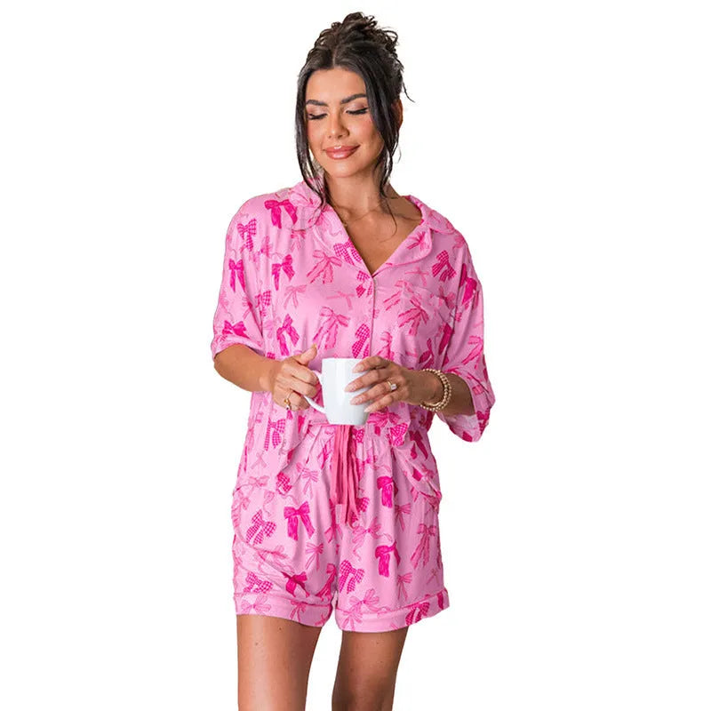 Pink floral bow print women's pyjama two-piece set on a hanger.