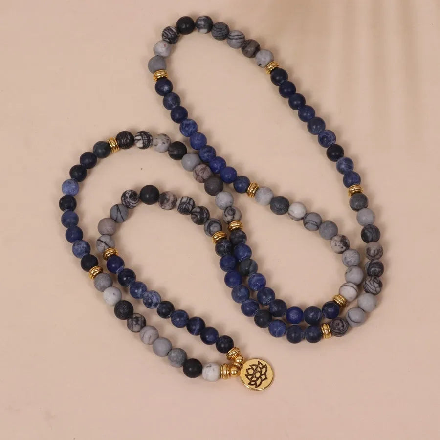 Close-up of a blue multi-layer bracelet with patterned network stone beads and a silver alloy chain.