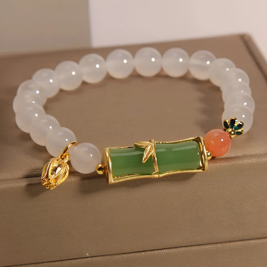 Women's white agate jade bracelet with bamboo joint design and a single bead centrepiece.