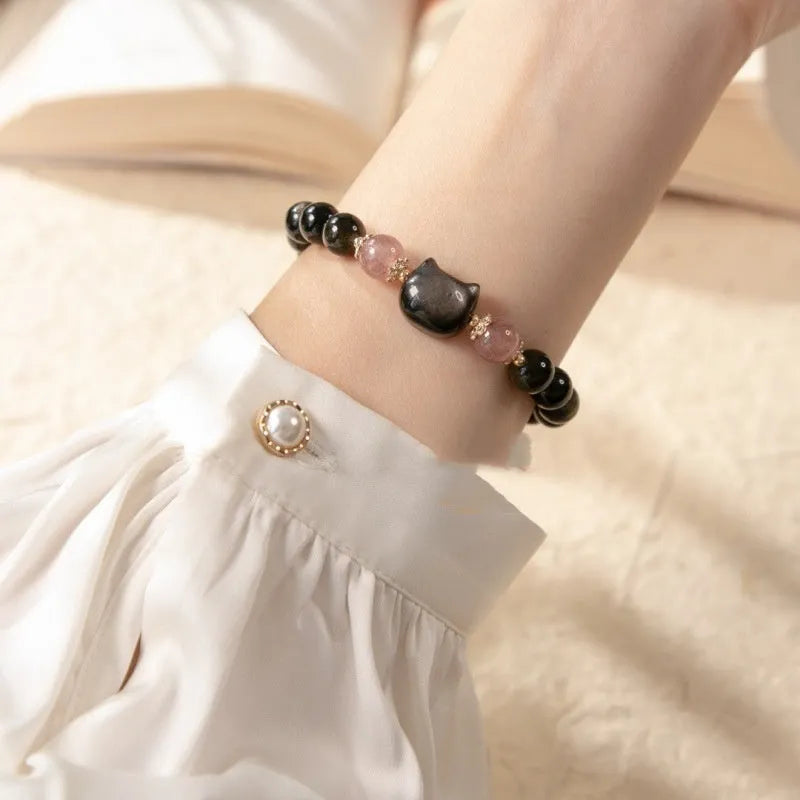Single circle natural obsidian bracelet with 8mm black beads and kitty cat pendant on white background