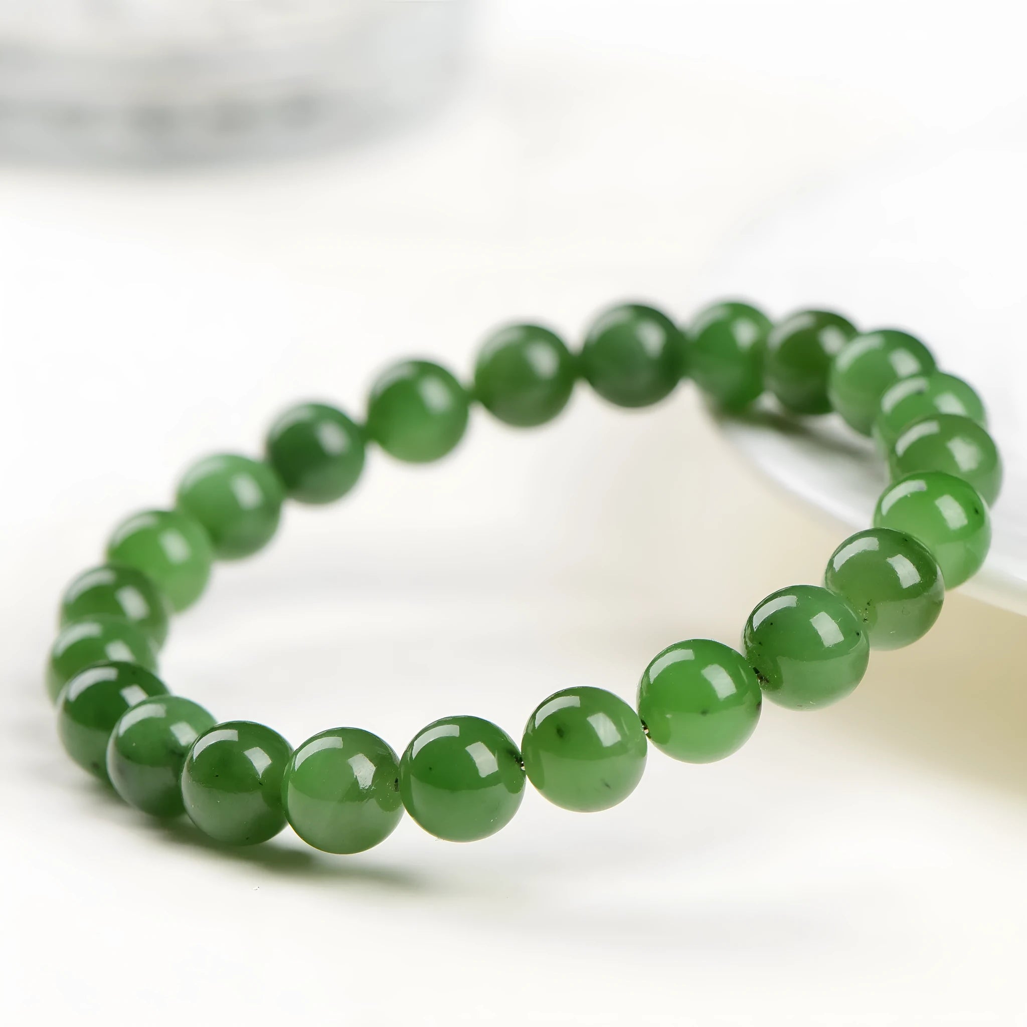 Polished Hetian jade bead bracelet in natural jasper colour on a wrist.