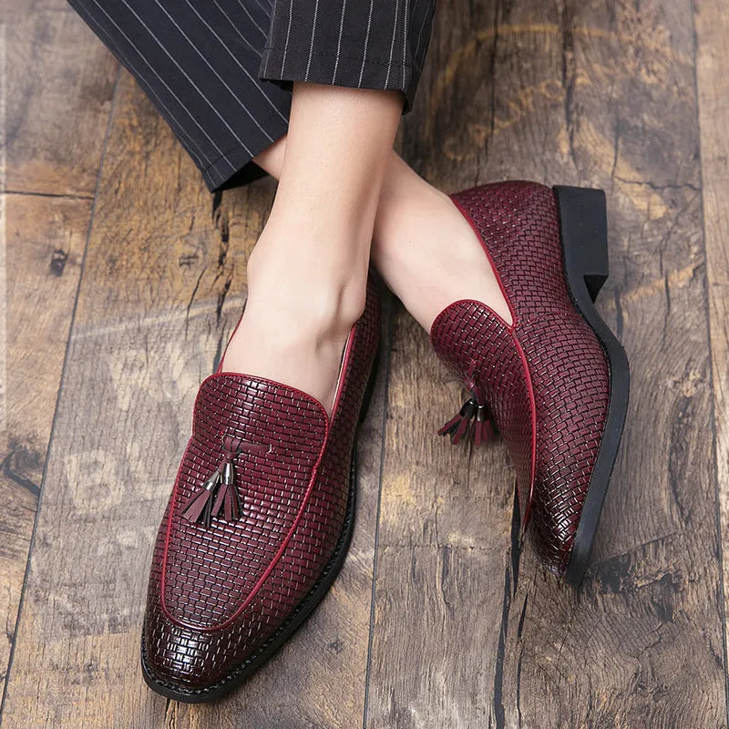 Men's black pointed slip-on leather shoes with a tassel detail on the low-top upper.